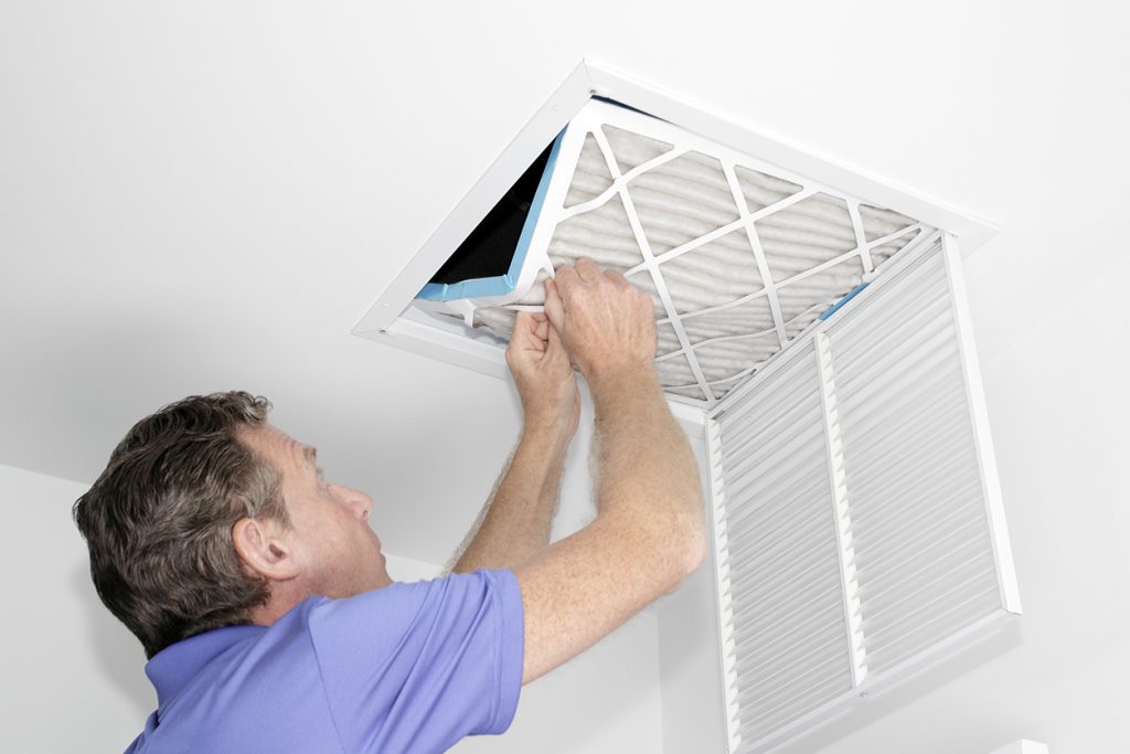 Person removing home ceiling filter